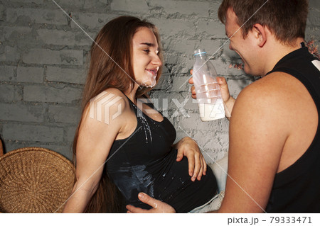young caucasian couple together having fun on kitchen, woman pregnant, drinking milk, lifestyle people concept 79333471