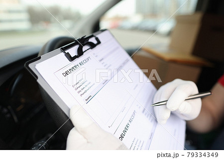Gloved courier filling out delivery receipt using ballpoint pen closeup Gloved courier filling out delivery receipt using ballpoint pen closeup 79334349