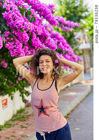 Beautiful young girl model brunette posing with blooming purple flowers in Turkey on the island of Buyukada 79336298