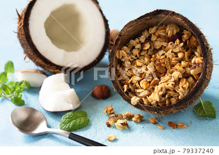 Coconut granola and coconut on a blue stone countertop. 79337240