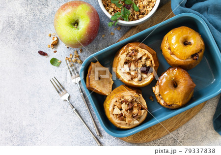 Diet Healthy dessert. Baked apples with walnuts, honey and granola on slate, stone or concrete background. Top view flat lay background. Copy space. 79337838