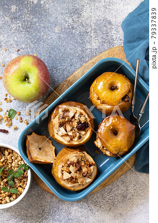 Diet Healthy dessert. Baked apples with walnuts, honey and granola on slate, stone or concrete background. Top view flat lay background. Copy space. Diet Healthy dessert. Baked apples with walnuts, honey and granola on slate, stone or concrete background. Top view flat lay background. Copy space. 79337839