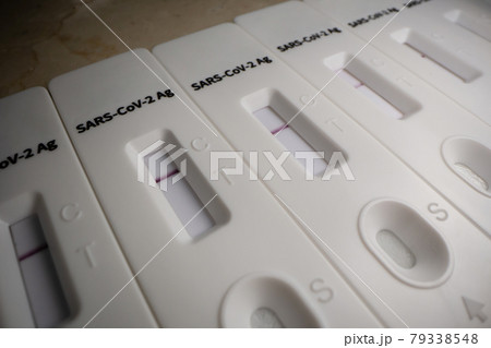 Macro close up of many negative SARS COV rapid antigen tests in row on white background. Coronavirus crisis. Global pandemic. Macro close up of many negative SARS COV rapid antigen tests in row on white background. Coronavirus crisis. Global pandemic. 79338548