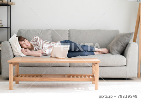 ソファーに寝ながらタブレット端末を見る女性 ソファーに寝ながらタブレット端末を見る女性 79339549