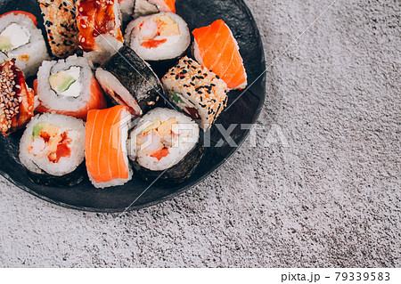 Sushi bar lunch menu. Top view of sushi rolls with salmon, avocado and smocked eel on the concrete table background with copy space. Order food online and home delivery food concept 79339583