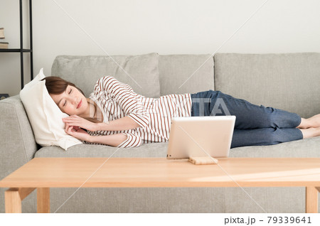 ソファーに寝ながらタブレット端末を見る女性 ソファーに寝ながらタブレット端末を見る女性 79339641