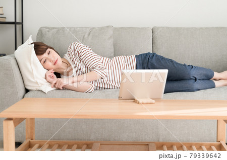 ソファーに寝ながらタブレット端末を見る女性 ソファーに寝ながらタブレット端末を見る女性 79339642