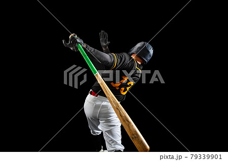 Professional baseball player, pitcher in sports uniform and equipment playing baseball isolated on black studio background in neon light. Rear view 79339901