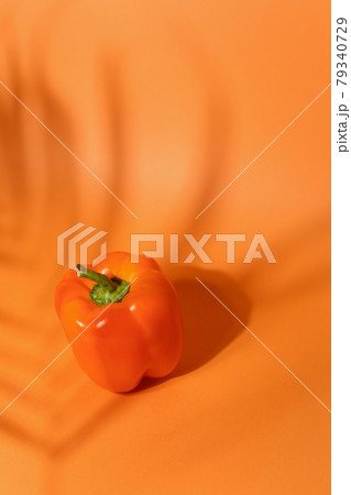 Fresh sweet orange pepper isolated on neutral orange background closeup 79340729