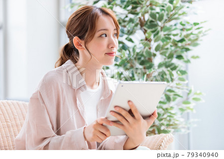 タブレットで読書、ネット閲覧をする若い女性 タブレットで読書、ネット閲覧をする若い女性 79340940