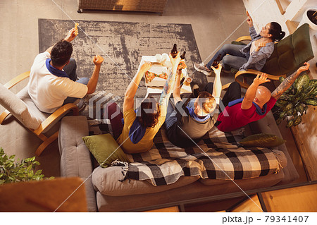 Group of friends watching TV, sport match together. Concept of friendship, leisure activity, emotions Group of friends watching TV, sport match together. Concept of friendship, leisure activity, emotions 79341407