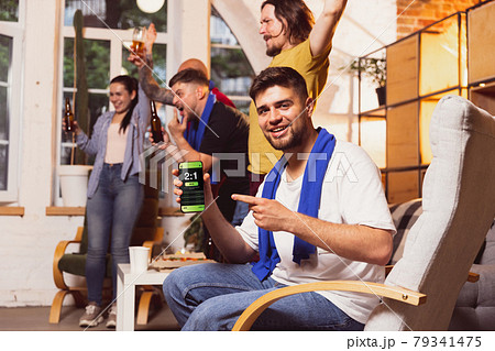 Bet for winner. Young men watching TV, sport match together. Concept of friendship, leisure activity, emotions Bet for winner. Young men watching TV, sport match together. Concept of friendship, leisure activity, emotions 79341475