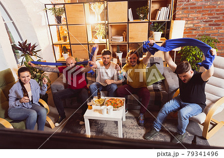 Young people watching TV, sport match together. Concept of friendship, leisure activity, emotions Young people watching TV, sport match together. Concept of friendship, leisure activity, emotions 79341496