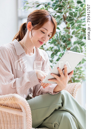 タブレットで読書、ネット閲覧をする若い女性 79341707