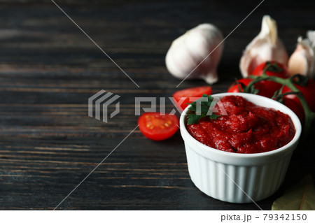 Bowl with tomato paste, tomatoes and garlic on wooden table Bowl with tomato paste, tomatoes and garlic on wooden table 79342150