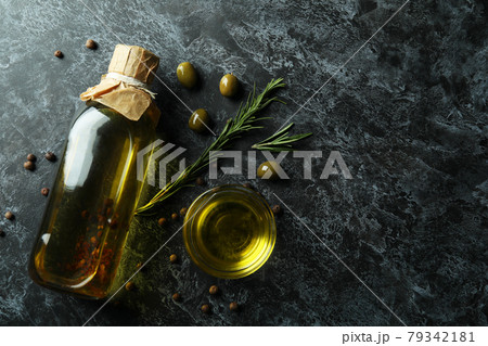Bottle and bowl with olive oil and spices on black smokey background 79342181