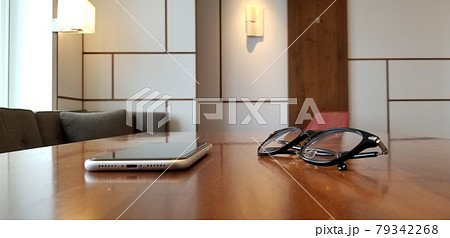 木製テーブルに置かれたスマホと眼鏡　モダンなインテリア 79342268