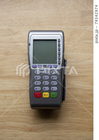 Close up shot of card machine or pos terminal on wooden table Close up shot of card machine or pos terminal on wooden table 79342974