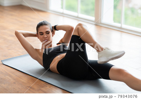 Smiling Young Woman Doing Twist Crunches Exercise 79343076