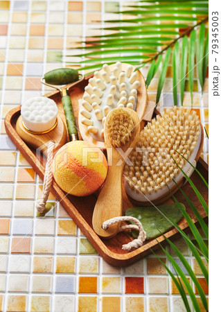 Jars of cream for face and body care, gold eye patches and serum with gold, jade roller massager gau-sha and massager and body brush against background of tile mosaic Jars of cream for face and body care, gold eye patches and serum with gold, jade roller massager gau-sha and massager and body brush against background of tile mosaic 79345003