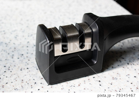 Black knife sharpener on the table closeup Black knife sharpener on the table closeup 79345467
