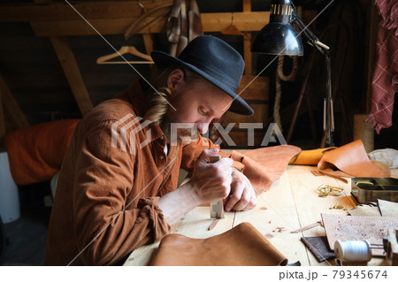 Shoemaker working at workshop 79345674