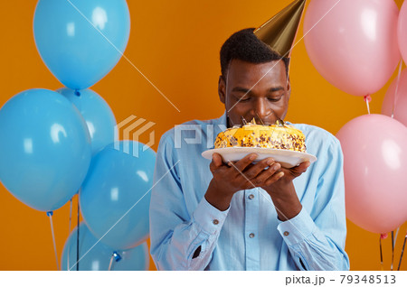 Cheerful man in cap tasting birthday cake Cheerful man in cap tasting birthday cake 79348513