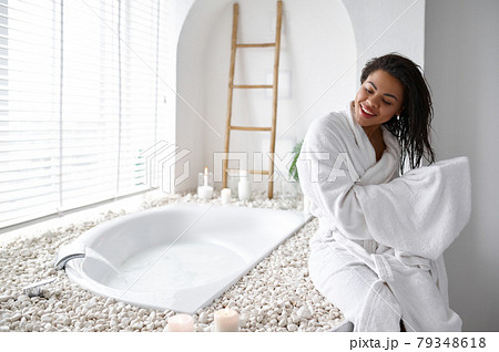 Woman in bathrobe wipes her hair with a towel Woman in bathrobe wipes her hair with a towel 79348618
