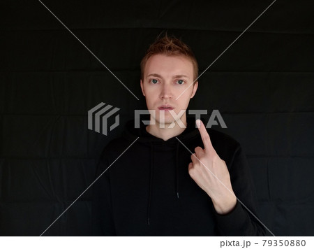 ジェスチャーで1を表している白人男性 黒背景 ジェスチャーで1を表している白人男性 黒背景 79350880