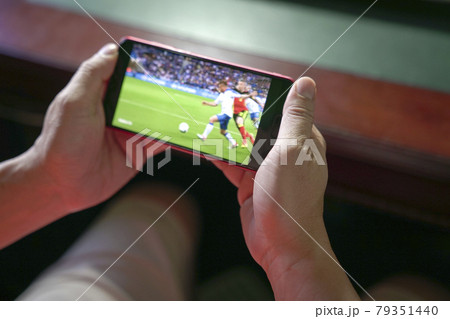 Man watching football and sport stream on mobile phone. 79351440