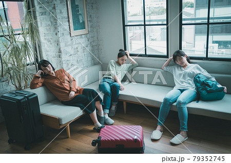 スーツケースと疲れる女性達の写真素材