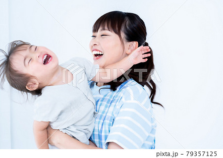 抱っこされて甘える女の子と保育士 抱っこされて甘える女の子と保育士 79357125