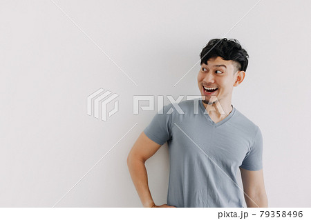 Happy face of Asian man look at an empty space isolated on white wall 79358496