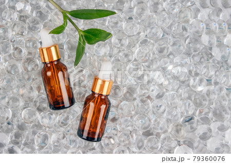 Mockup image of two dropper bottles with natural organic herbal cosmetic oil on light background of water gel balls. Trendy flat lay composition with copy space. Modern organic apothecary concept Mockup image of two dropper bottles with natural organic herbal cosmetic oil on light background of water gel balls. Trendy flat lay composition with copy space. Modern organic apothecary concept 79360076