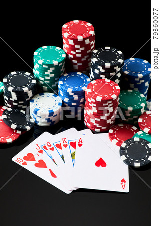 Stack of Casino gambling chips and cards isolated on black reflective background 79360077