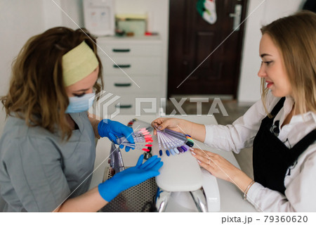Female manicure master in a beauty salon work with hands of the client Female manicure master in a beauty salon work with hands of the client 79360620