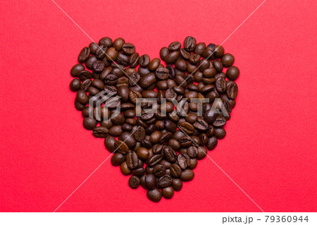 Grains of coffee in the form of heart on a red background Grains of coffee in the form of heart on a red background 79360944