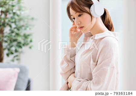 ヘッドフォンで音楽に聴き入る若い女性 ヘッドフォンで音楽に聴き入る若い女性 79363184