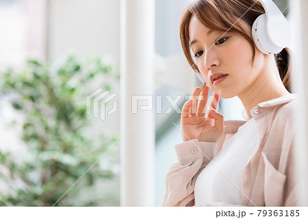 ヘッドフォンで音楽に聴き入る若い女性 ヘッドフォンで音楽に聴き入る若い女性 79363185