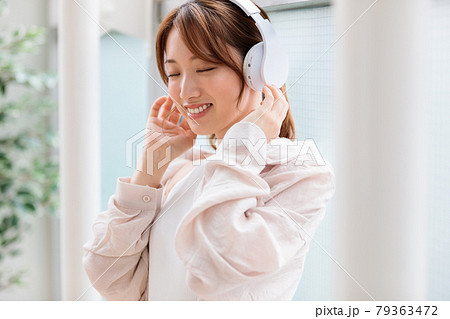 ヘッドフォンで音楽に聴き入る若い女性 ヘッドフォンで音楽に聴き入る若い女性 79363472