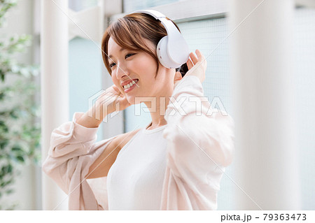ヘッドフォンで音楽に聴き入る若い女性 ヘッドフォンで音楽に聴き入る若い女性 79363473