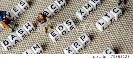 set of popular crypto coins forming rows made of white cubes with black capital letters and miniature businessmen figurines having a team meeting 79363523