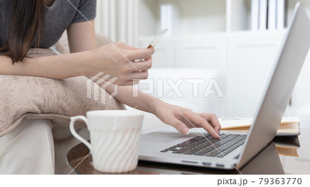 Asian woman lounging on sofa and using laptop to shop online with credit card to register for payment or online transactions, Financial transactions and Internet security, Shopping with credit card. Asian woman lounging on sofa and using laptop to shop online with credit card to register for payment or online transactions, Financial transactions and Internet security, Shopping with credit card. 79363770