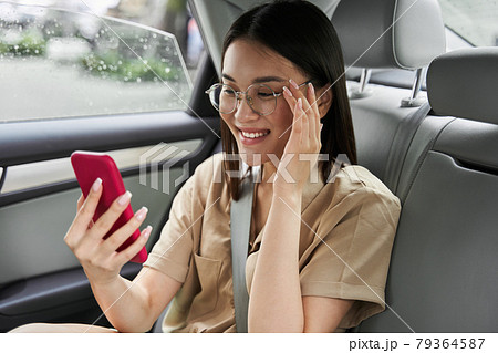 Woman looking at the smartphone screen and smiling toothy while having video chat 79364587