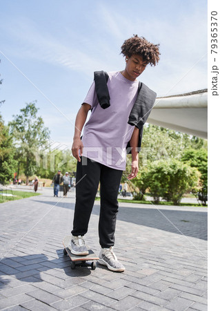 Active man practicing skateboarding while spending time in urban settings 79365370