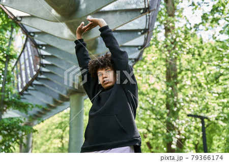 Man wearing sports clothes warming up before jogging on the street Man wearing sports clothes warming up before jogging on the street 79366174