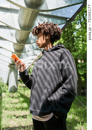 Man wearing casual clothes standing at the street and looking at his smartphone Man wearing casual clothes standing at the street and looking at his smartphone 79366177