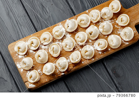 Raw meat dumplings on wooden board on table Raw meat dumplings on wooden board on table 79366780