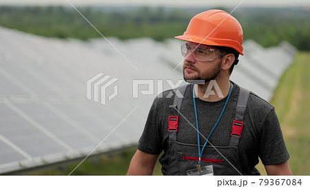 Close up man energy technician walk on solar panels field and inspecting photovoltaic solar panels. Concept.renewable energy, technology, green, future. Close up man energy technician walk on solar panels field and inspecting photovoltaic solar panels. Concept.renewable energy, technology, green, future. 79367084