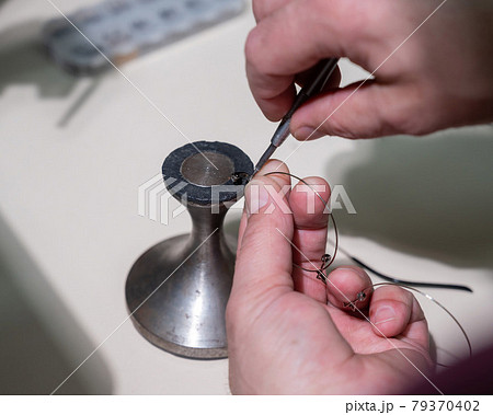 Optical technician fixing glasses. Close-up of male hands with screwdriver and goggles frame. Optical technician fixing glasses. Close-up of male hands with screwdriver and goggles frame. 79370402